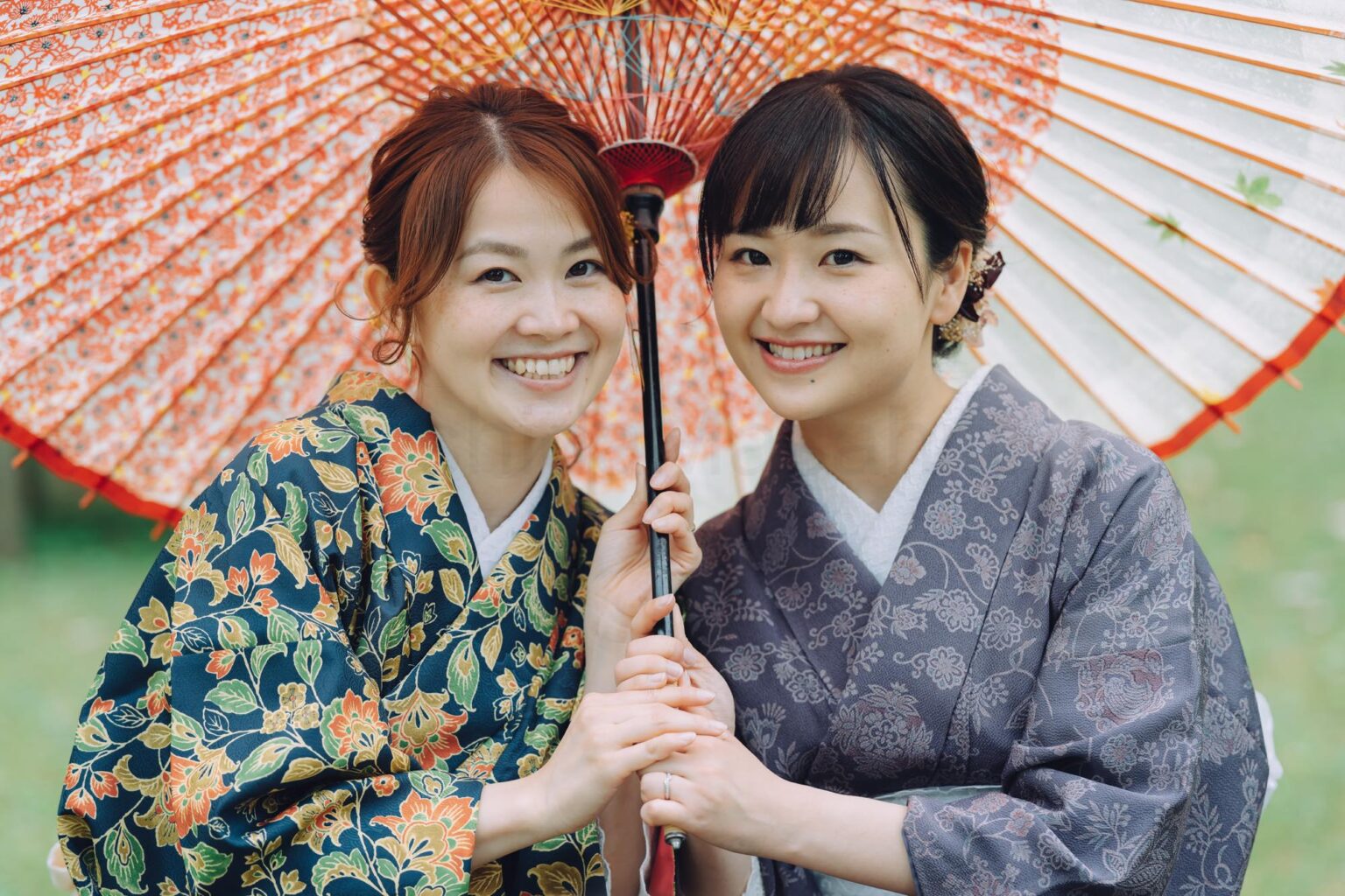 和傘の下で寄り添う着物姿の二人