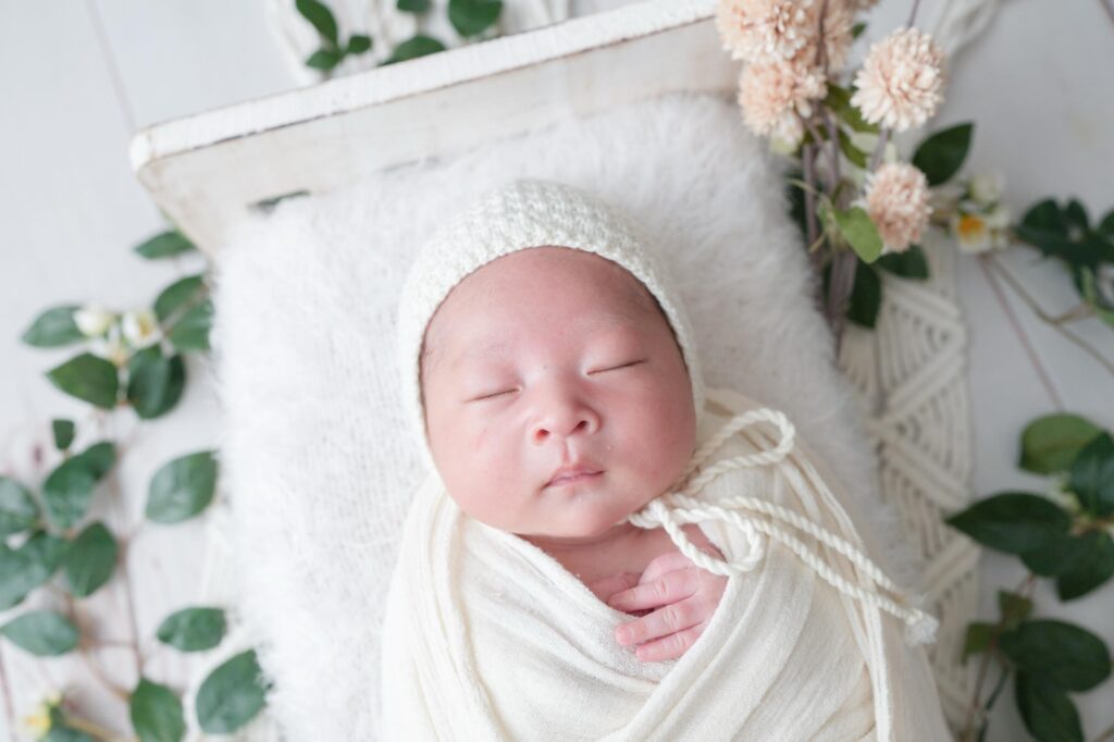 安曇野市でのニューボーンフォト|白いおくるみにシンプルな帽子をかぶった赤ちゃんの写真