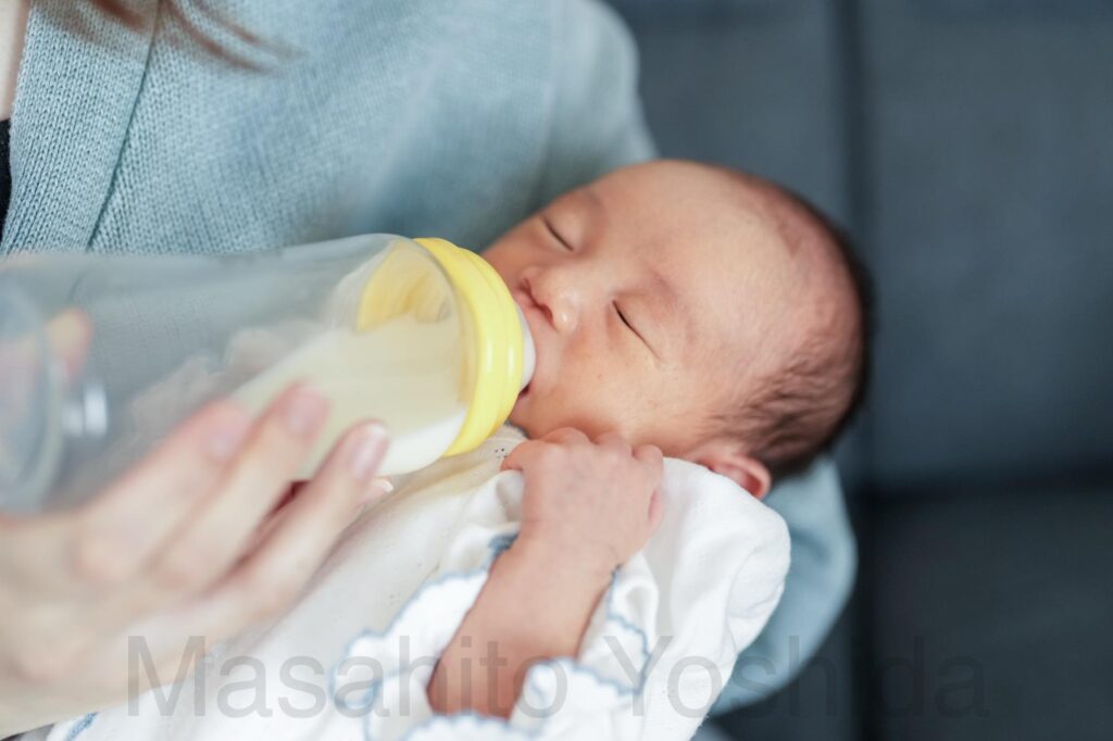 上伊那郡南箕輪村でニューボーンフォト|ママの腕の中で哺乳瓶からミルクを飲む赤ちゃん。